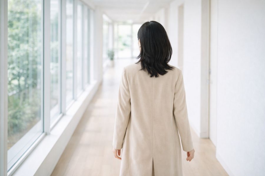 クリニックの廊下を歩く女性の後ろ姿