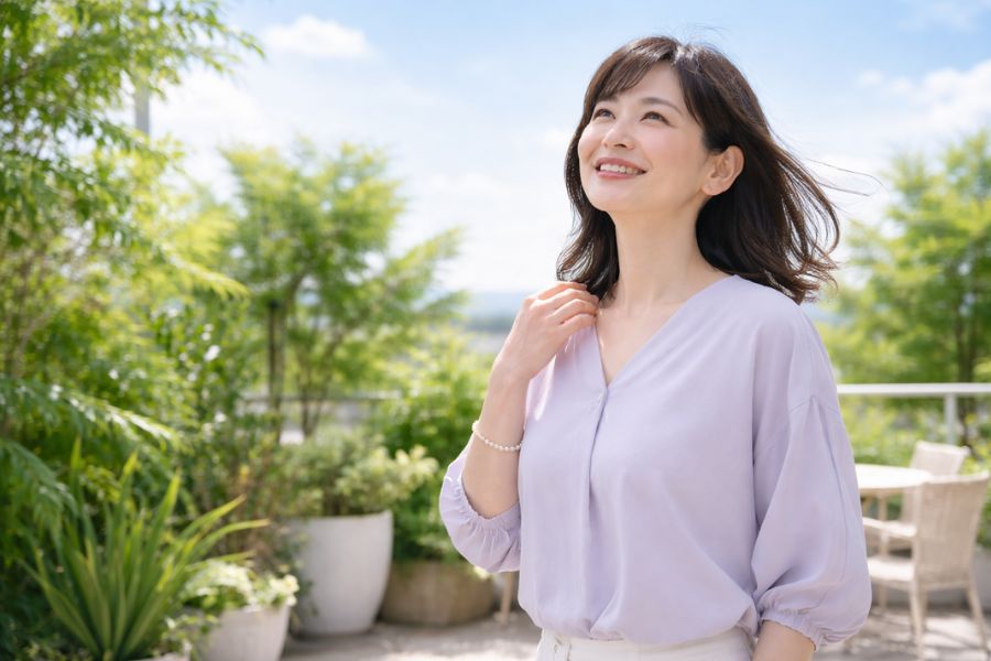 屋外テラスで明るい笑顔を見せる女性