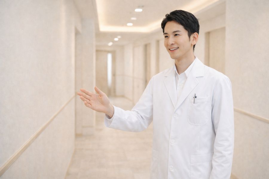 クリニック廊下で身ぶりを交えて話す男性医師