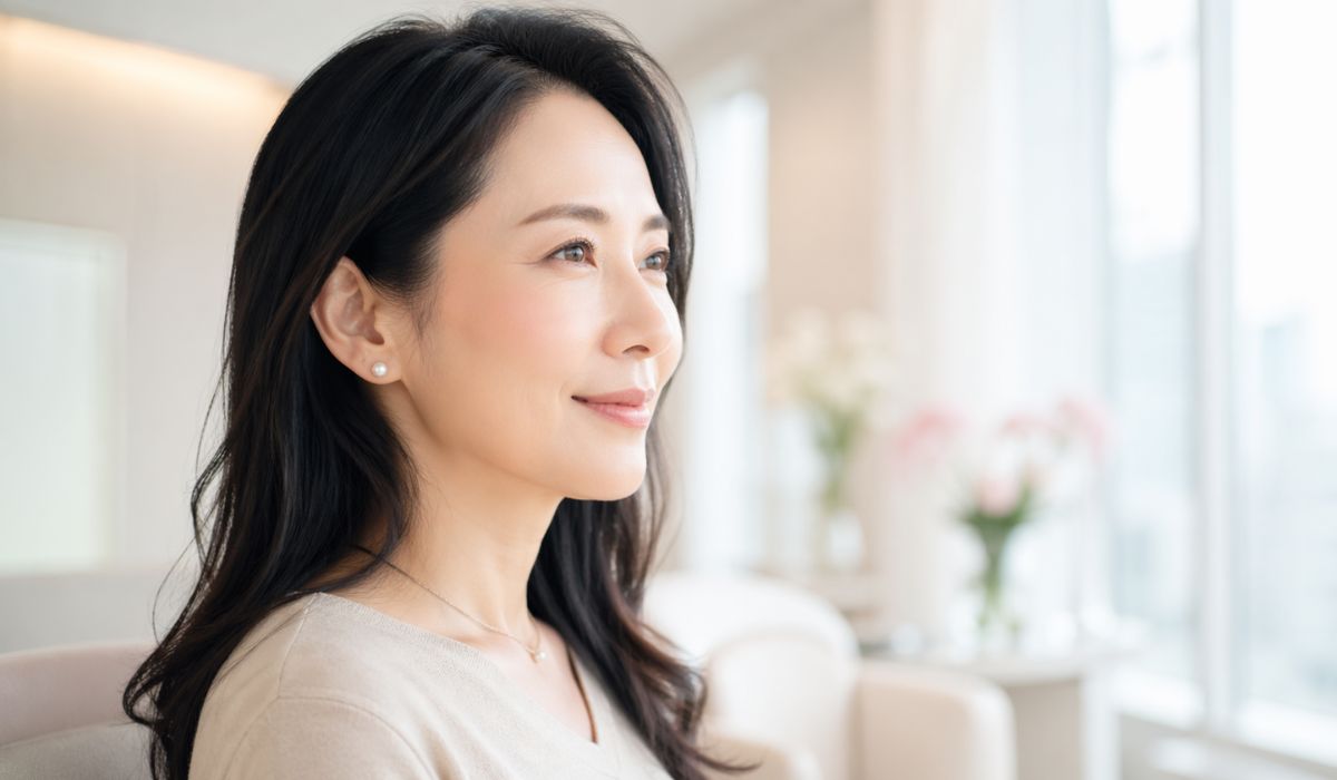 明るい室内で横顔を見せて微笑む日本人女性