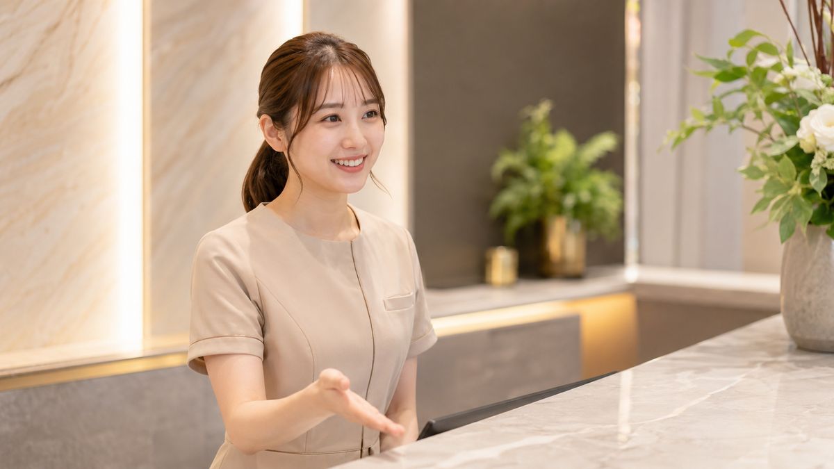 清潔な美容クリニックの受付で来院者を迎える受付スタッフ
