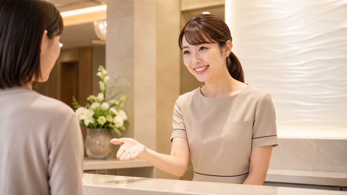 受付カウンターで案内する女性スタッフ