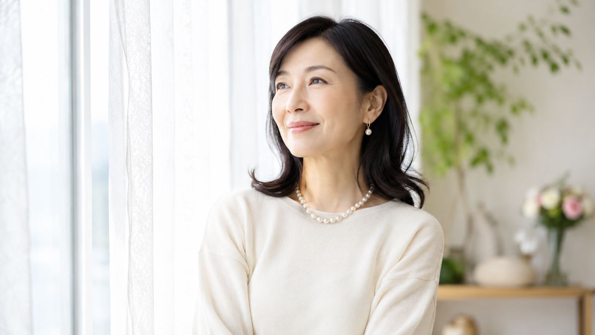 窓辺で穏やかにほほ笑む女性