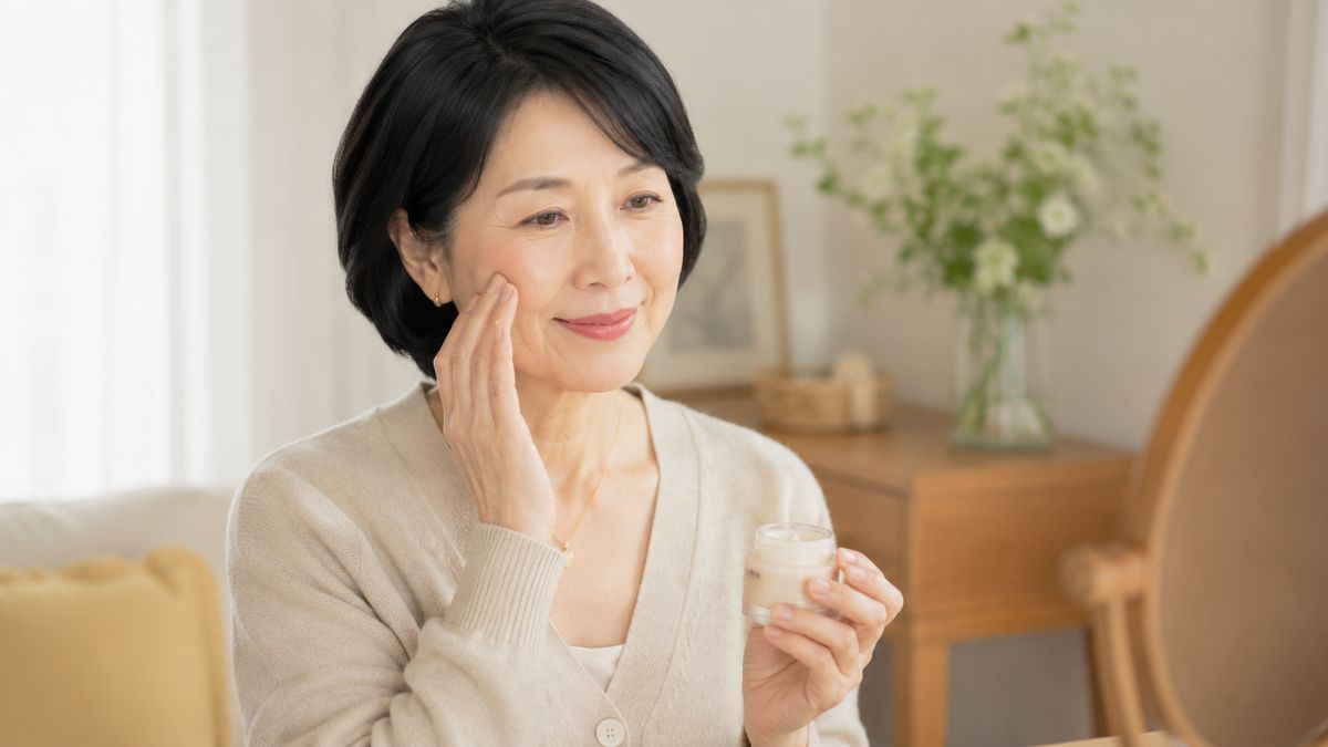 口横のたるみ予防のスキンケアをする女性