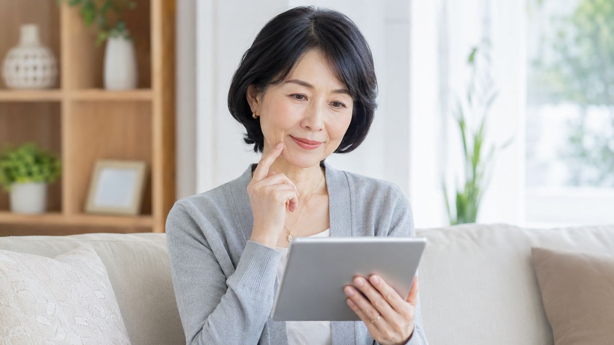口横のたるみについて情報を調べる女性