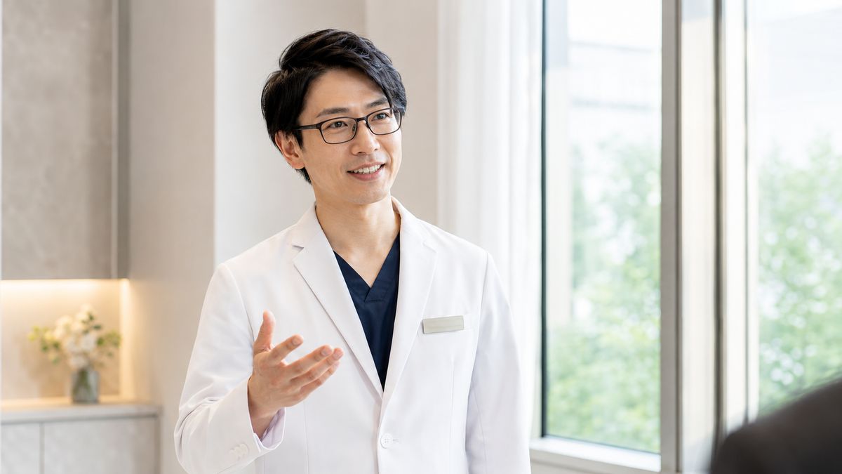 窓辺で説明する眼鏡の男性医師