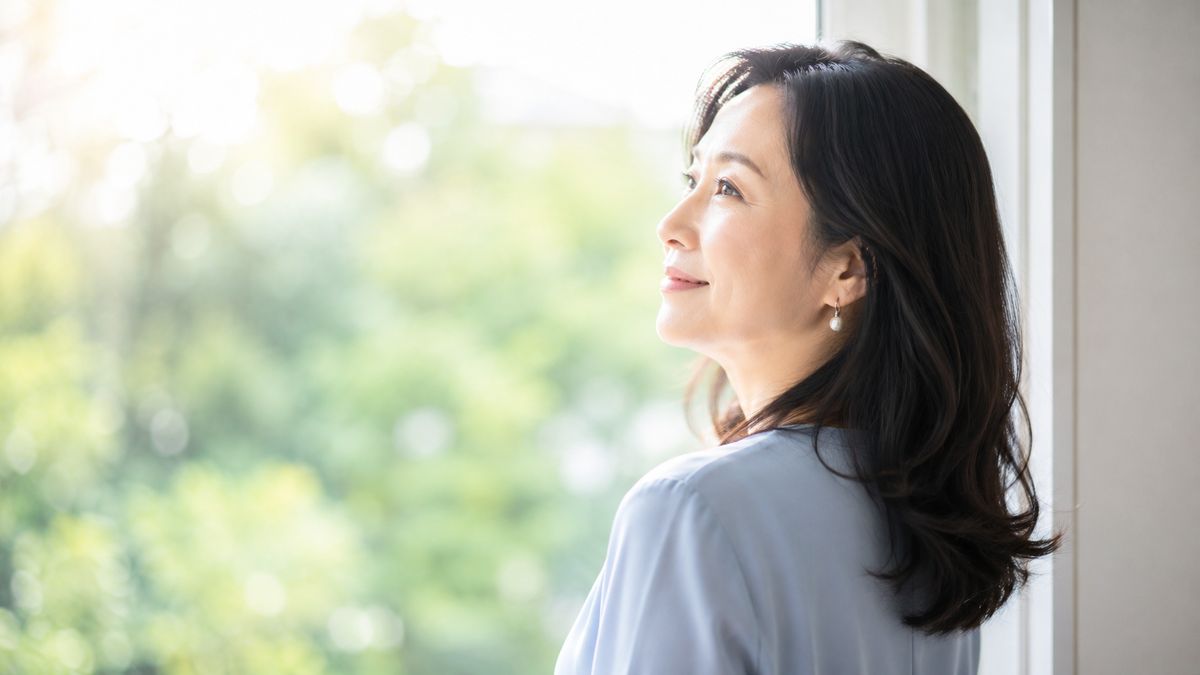 窓辺で外を眺めている女性の横顔