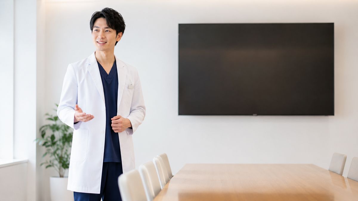 カンファレンスルームで話す白衣の男性医師