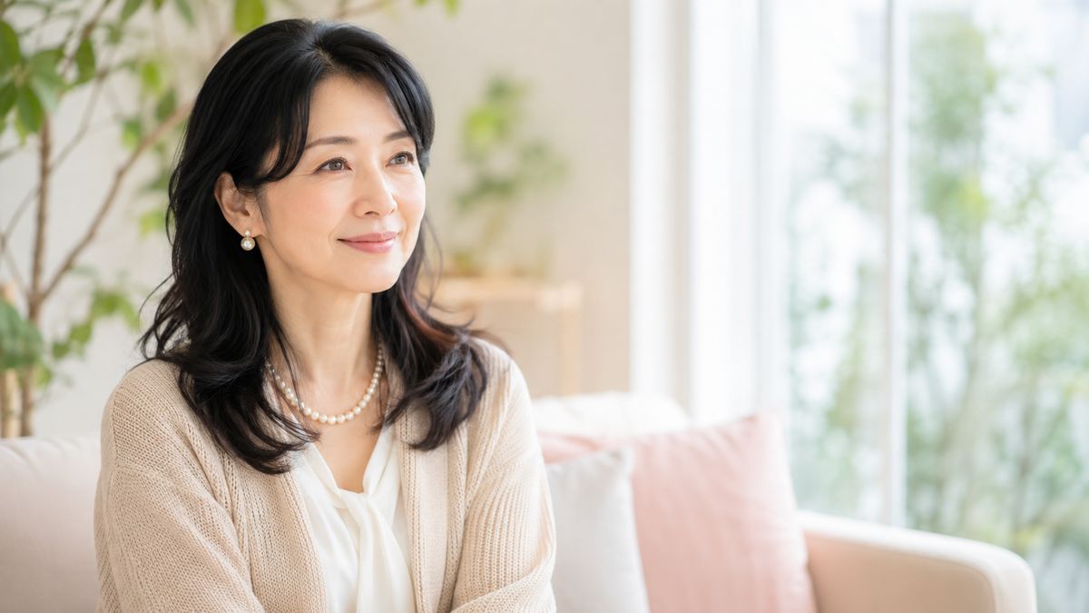クリニックのラウンジのソファに座って微笑む女性