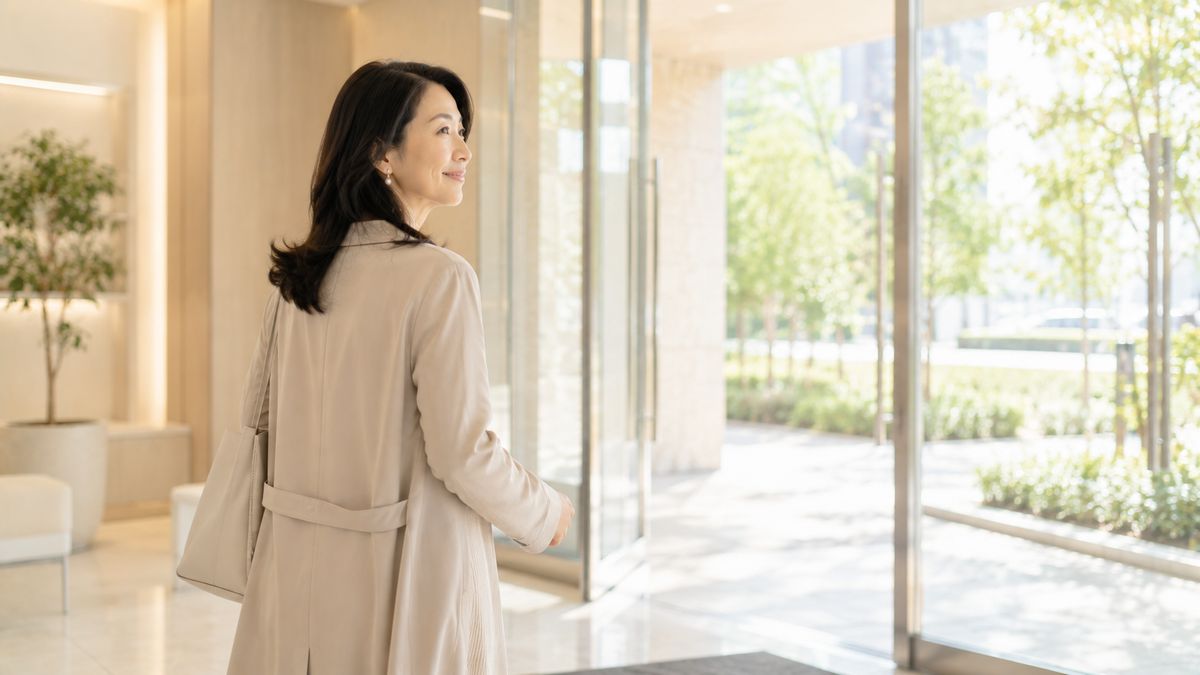 クリニックのエントランスを出て歩き出す女性