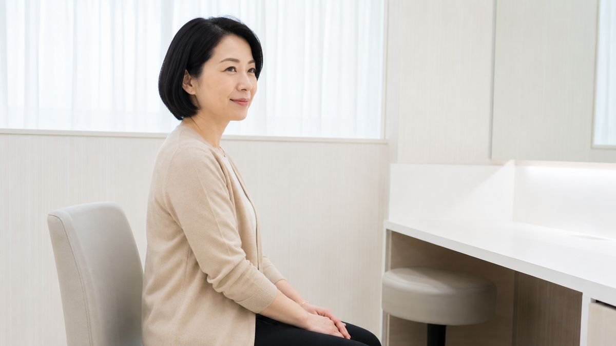 検査室の椅子に腰かけて待つ女性の横顔