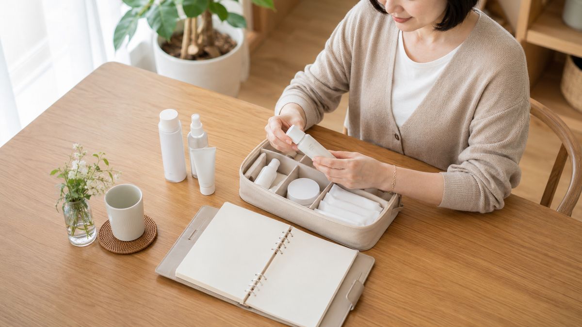 ダイニングテーブルで手帳とケースを手に取る女性