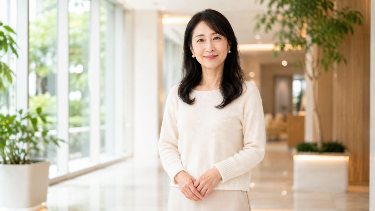 明るいクリニックのエントランスで前を向いて立つ女性