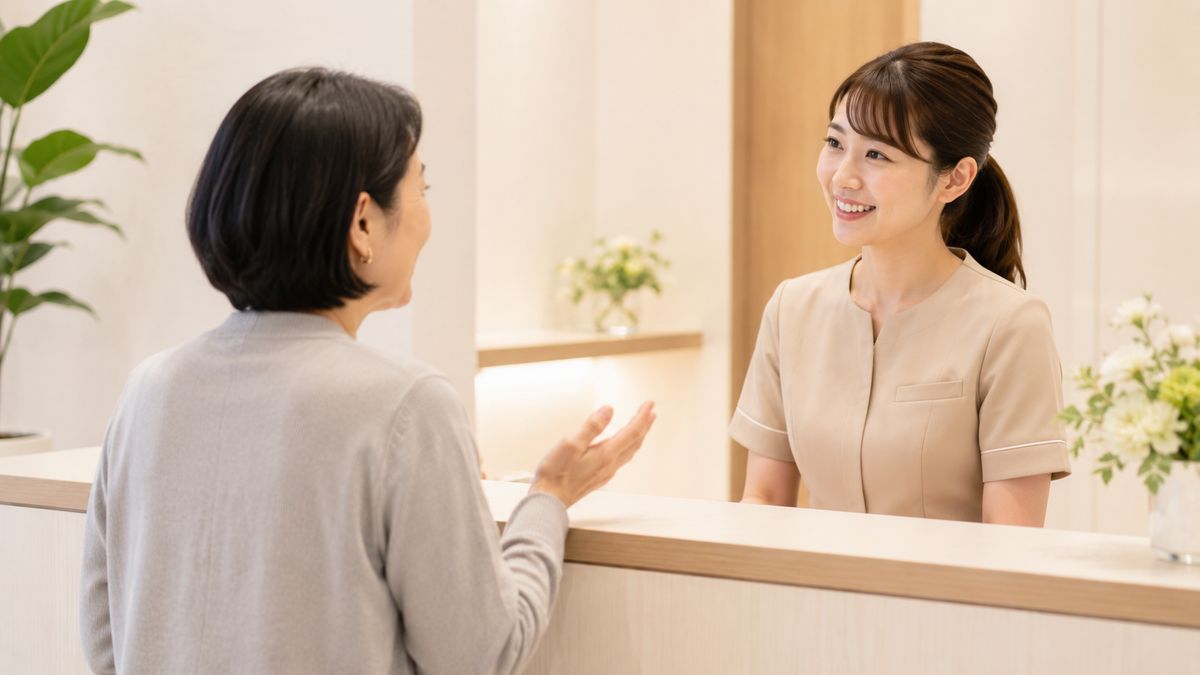受付カウンターでスタッフに質問している女性