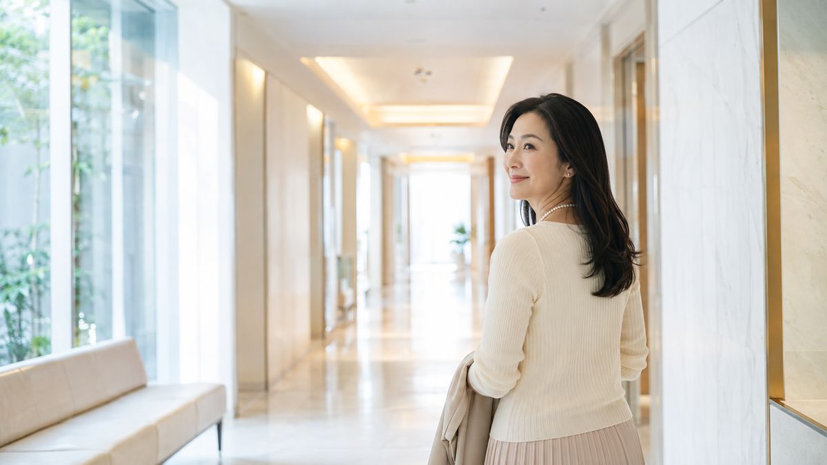 明るいクリニックの廊下を歩く女性
