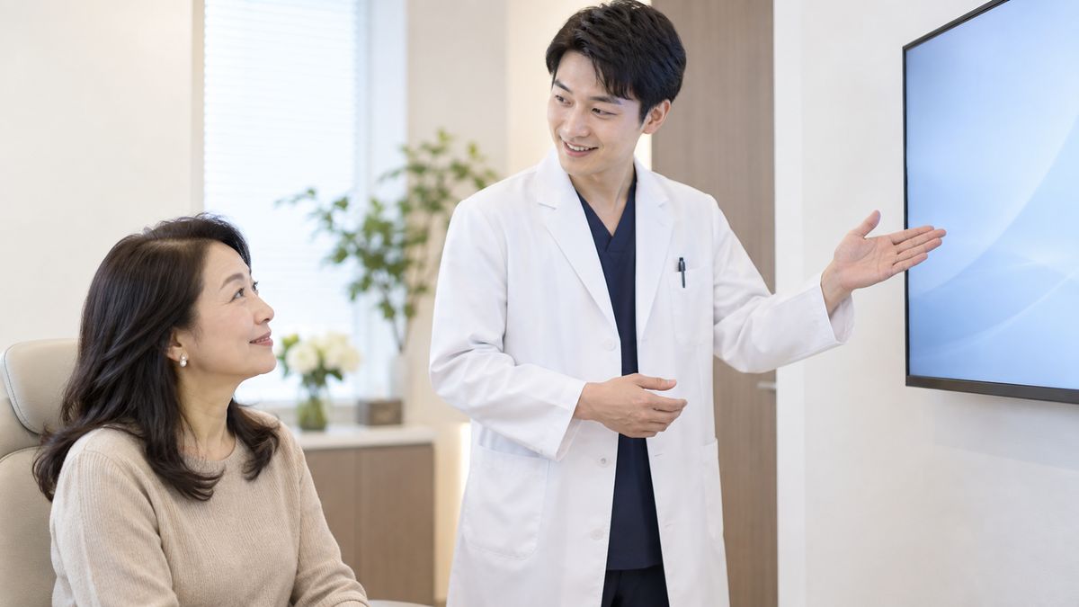 立って説明する医師と座って聞く女性