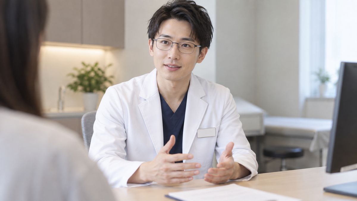 診察室で落ち着いて説明する眼鏡の男性医師