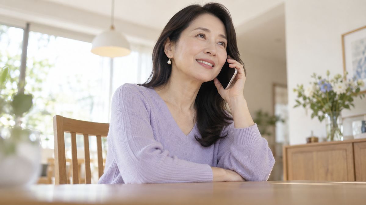 ダイニングでスマートフォンで電話をする女性