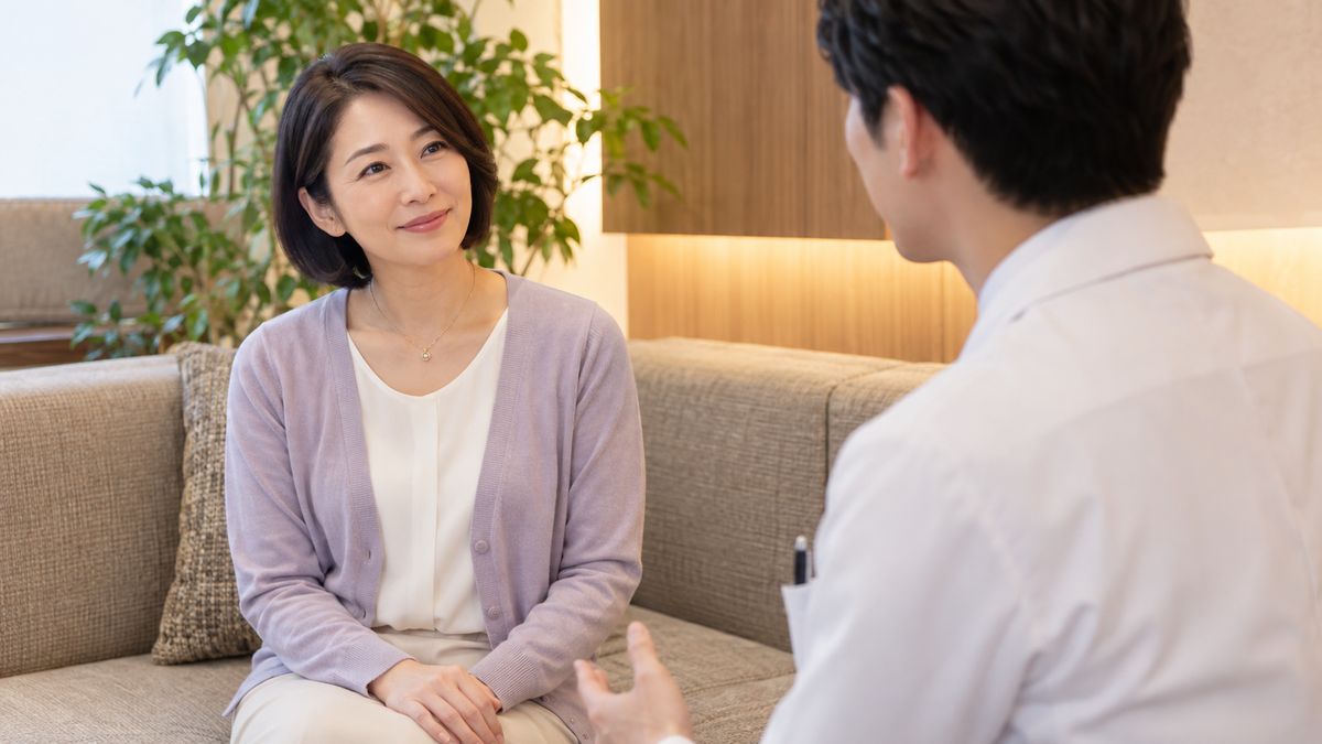 ソファに並んで座り男性医師と話す女性