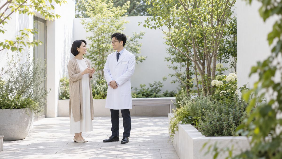 中庭で眼鏡の男性医師と立ち話をする女性
