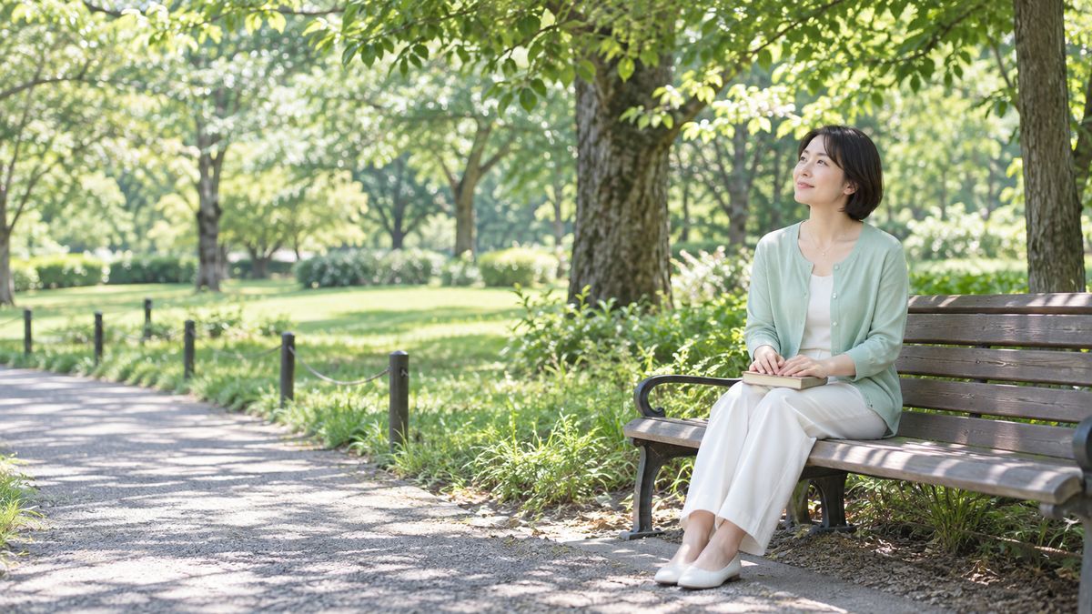 公園のベンチに座り遠くを見るボブヘアの女性