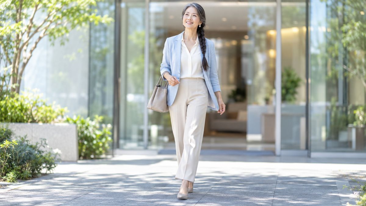 クリニックの入口から歩き出す三つ編みの女性
