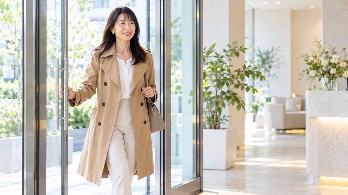 クリニックのガラス扉を開けて入ってくる女性
