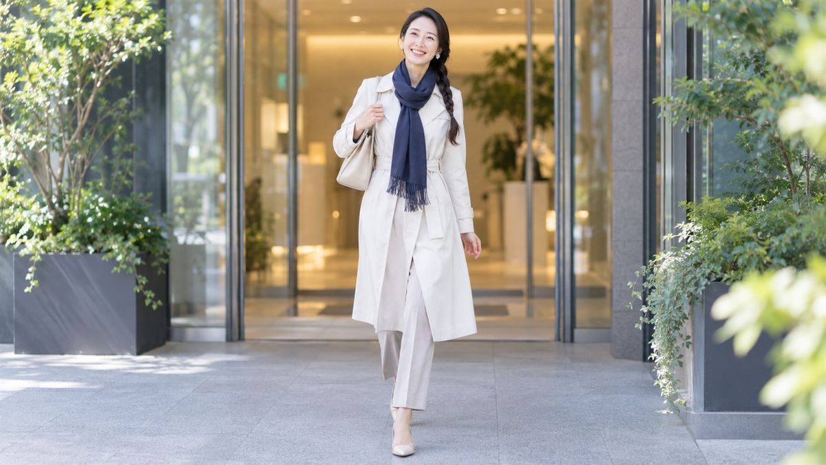 クリニックの入口から歩き出す三つ編みの女性